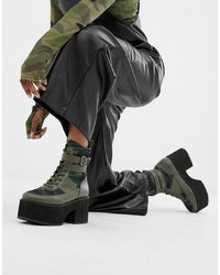 dunkelgrüne flache Stiefel mit einer Schnürung aus Leder
