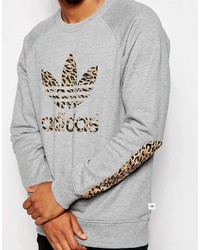 grauer Pullover mit einem Rundhalsausschnitt mit Leopardenmuster von adidas