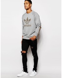 grauer Pullover mit einem Rundhalsausschnitt mit Leopardenmuster von adidas