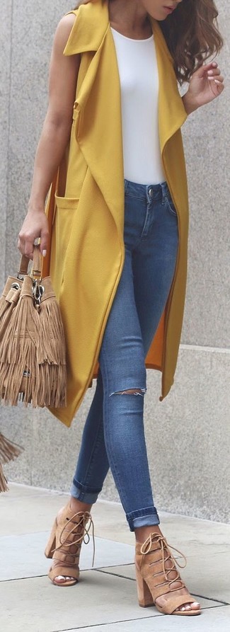 Beige Wildleder Sandaletten kombinieren – 116 Damen Outfits: Probieren Sie diese Kombination aus einem gelben ärmellosem Mantel und blauen engen Jeans mit Destroyed-Effekten, um ein stilsicheres Alltags-Outfit zu kreieren. Beige Wildleder Sandaletten sind eine kluge Wahl, um dieses Outfit zu vervollständigen.