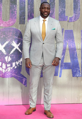 Adewale Akinnuoye-Agebaje trägt grauer Anzug, weißes Businesshemd, beige Leder Derby Schuhe, senf Krawatte