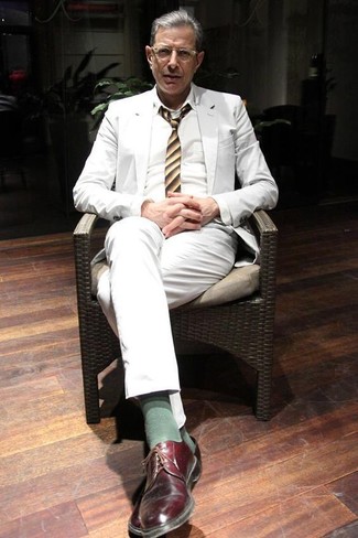 Jeff Goldblum trägt weißer Anzug, weißes Businesshemd, dunkelrote Leder Derby Schuhe, gelbe vertikal gestreifte Krawatte