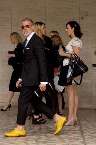 50 Jährige: Goldene Schuhe kombinieren – 5 Elegante Herren Outfits: Kombinieren Sie einen schwarzen Anzug mit einem weißen Businesshemd für eine klassischen und verfeinerte Silhouette. Fühlen Sie sich ideenreich? Komplettieren Sie Ihr Outfit mit gelben Leder Derby Schuhen.