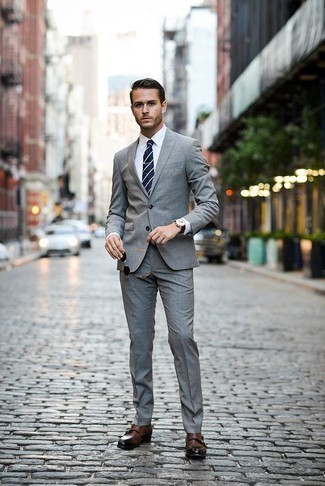 20 Jährige: Blaue horizontal gestreifte Krawatte kombinieren – 43 Herren Outfits: Kombinieren Sie einen grauen Anzug mit einer blauen horizontal gestreiften Krawatte für einen stilvollen, eleganten Look. Fühlen Sie sich ideenreich? Ergänzen Sie Ihr Outfit mit braunen Doppelmonks aus Leder.