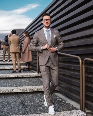 20 Jährige: Dunkelgraue Krawatte kombinieren – 26 Smart-Casual Herren Outfits: Vereinigen Sie einen braunen vertikal gestreiften Anzug mit einer dunkelgrauen Krawatte, um vor Klasse und Perfektion zu strotzen. Suchen Sie nach leichtem Schuhwerk? Wählen Sie weißen Segeltuch niedrige Sneakers für den Tag.