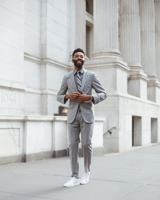Wie grauen Anzug mit weißer Segeltuch niedriger Sneakers zu kombinieren – 10 Elegante Herren Outfits: Kombinieren Sie einen grauen Anzug mit einem grauen Businesshemd für eine klassischen und verfeinerte Silhouette. Suchen Sie nach leichtem Schuhwerk? Ergänzen Sie Ihr Outfit mit weißen Segeltuch niedrigen Sneakers für den Tag.