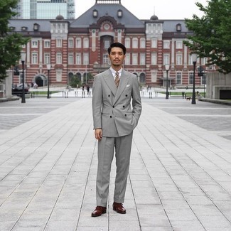Elegante Outfits Herren 2024: Kombinieren Sie einen grauen Anzug mit einem weißen Businesshemd, um vor Klasse und Perfektion zu strotzen. Komplettieren Sie Ihr Outfit mit dunkelbraunen Leder Oxford Schuhen.