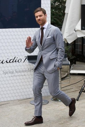 Gepunktete Socken kombinieren – 131 Elegante Herren Outfits: Kombinieren Sie einen grauen Anzug mit gepunkteten Socken, um einen lockeren, aber dennoch stylischen Look zu erhalten. Fühlen Sie sich ideenreich? Entscheiden Sie sich für dunkelbraunen Leder Oxford Schuhe.