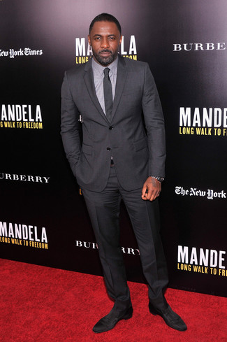 Idris Elba trägt dunkelgrauer Anzug, graues Businesshemd, schwarze Wildleder Slipper, dunkelgraue Krawatte