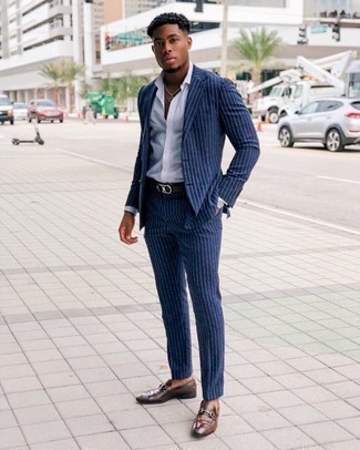 Braune Leder Slipper kombinieren – 1200+ Herren Outfits: Erwägen Sie das Tragen von einem dunkelblauen vertikal gestreiften Anzug und einem weißen Businesshemd, um vor Klasse und Perfektion zu strotzen. Braune Leder Slipper sind eine großartige Wahl, um dieses Outfit zu vervollständigen.