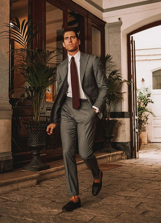 Dunkelbraune Krawatte mit Paisley-Muster kombinieren – 40 Sommer Herren Outfits: Kombinieren Sie einen grauen vertikal gestreiften Anzug mit einer dunkelbraunen Krawatte mit Paisley-Muster für eine klassischen und verfeinerte Silhouette. Fühlen Sie sich mutig? Komplettieren Sie Ihr Outfit mit dunkelbraunen geflochtenen Leder Slippern. Schon mal so einen coolen Sommer-Outfit gesehen?