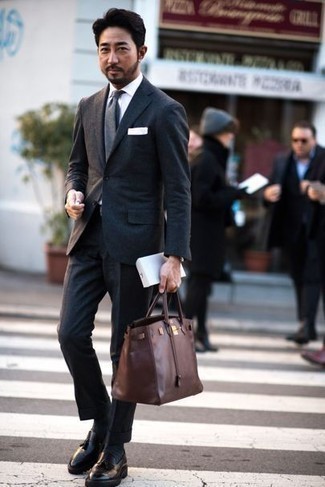 40 Jährige: Graue Krawatte kombinieren – 10 Elegante Frühling Herren Outfits: Paaren Sie einen dunkelgrauen Wollanzug mit einer grauen Krawatte für eine klassischen und verfeinerte Silhouette. Fühlen Sie sich mutig? Ergänzen Sie Ihr Outfit mit schwarzen Leder Slippern mit Quasten. Was für eine tolle Frühlings-Outfit Idee!