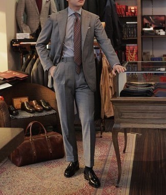 Dunkelbraune Krawatte mit geometrischem Muster kombinieren – 7 Herren Outfits: Paaren Sie einen grauen Anzug mit einer dunkelbraunen Krawatte mit geometrischem Muster für einen stilvollen, eleganten Look. Wenn Sie nicht durch und durch formal auftreten möchten, entscheiden Sie sich für schwarzen Leder Slipper mit Quasten.