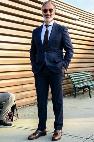 Schwarzen Ledergürtel kombinieren – 500+ Elegante Herren Outfits: Die Vielseitigkeit von einem dunkelblauen vertikal gestreiften Anzug und einem schwarzen Ledergürtel machen sie zu einer lohnenswerten Investition. Wählen Sie braunen Leder Slipper mit Quasten, um Ihr Modebewusstsein zu zeigen.