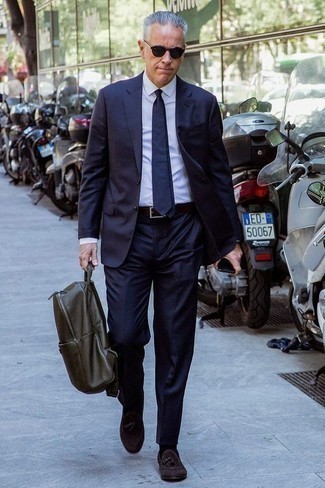 Olivgrünen Leder Rucksack kombinieren – 6 Herren Outfits: Vereinigen Sie einen dunkelblauen Anzug mit einem olivgrünen Leder Rucksack, um mühelos alles zu meistern, was auch immer der Tag bringen mag. Fühlen Sie sich ideenreich? Wählen Sie dunkelbraunen Wildleder Slipper mit Quasten.