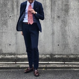 Rote bedruckte Krawatte kombinieren – 217 Herren Outfits: Kombinieren Sie einen dunkelblauen vertikal gestreiften Anzug mit einer roten bedruckten Krawatte, um vor Klasse und Perfektion zu strotzen. Machen Sie diese Aufmachung leger mit dunkelbraunen Leder Slippern mit Quasten.