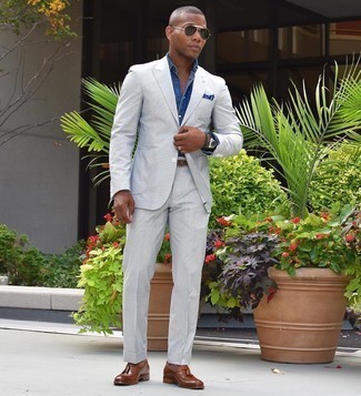 20 Jährige: Blaues Einstecktuch kombinieren – 66 Elegante Herren Outfits warm Wetter: Vereinigen Sie einen grauen Anzug mit einem blauen Einstecktuch für ein großartiges Wochenend-Outfit. Fühlen Sie sich ideenreich? Wählen Sie braunen Leder Slipper mit Quasten.