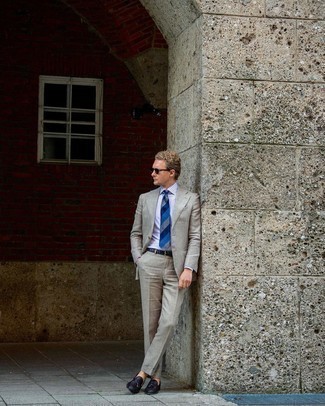 Blaue horizontal gestreifte Krawatte kombinieren – 500+ Herren Outfits: Machen Sie sich mit einem grauen Anzug und einer blauen horizontal gestreiften Krawatte einen verfeinerten, eleganten Stil zu Nutze. Machen Sie diese Aufmachung leger mit dunkelbraunen geflochtenen Leder Slippern mit Quasten.