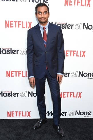 Aziz Ansari trägt dunkelblauer Anzug, hellblaues Businesshemd, schwarze Leder Derby Schuhe, dunkelrote vertikal gestreifte Krawatte