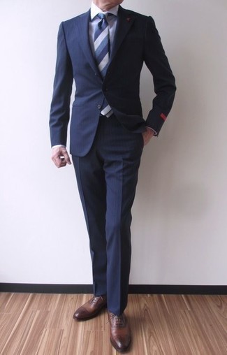 50 Jährige: Dunkelblauen vertikal gestreiften Anzug kombinieren – 44 Herren Outfits: Vereinigen Sie einen dunkelblauen vertikal gestreiften Anzug mit einem weißen Businesshemd für eine klassischen und verfeinerte Silhouette. Braune Leder Oxford Schuhe sind eine ideale Wahl, um dieses Outfit zu vervollständigen.