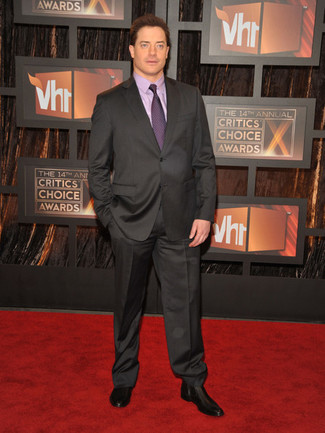 Brendan Fraser trägt dunkelgrauer Anzug, hellviolettes Businesshemd, schwarze Chelsea-Stiefel aus Leder, lila Krawatte