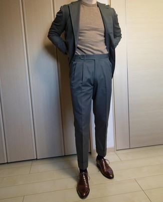 Dunkelgrauen Anzug kombinieren – 500+ Herren Outfits: Kombinieren Sie einen dunkelgrauen Anzug mit einem beige Pullover mit einem Rundhalsausschnitt für einen stilvollen, eleganten Look. Dunkelbraune Leder Oxford Schuhe bringen klassische Ästhetik zum Ensemble.