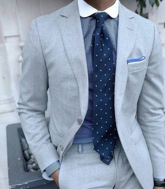 grauer Anzug, blaues Businesshemd mit Karomuster, dunkelblaue gepunktete Krawatte, weißes Einstecktuch für Herren