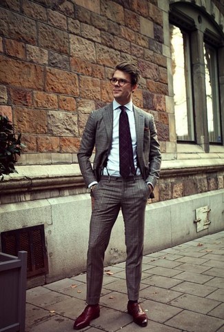 Violette Krawatte mit Schottenmuster kombinieren – 5 Herren Outfits: Entscheiden Sie sich für einen grauen Anzug mit Karomuster und eine violette Krawatte mit Schottenmuster für einen stilvollen, eleganten Look. Rote Leder Oxford Schuhe fügen sich nahtlos in einer Vielzahl von Outfits ein.
