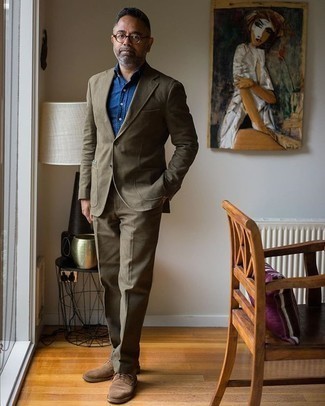 50 Jährige: Dunkelgrünen Anzug kombinieren – 17 Elegante Herren Outfits warm Wetter: Kombinieren Sie einen dunkelgrünen Anzug mit einem blauen Chambray Businesshemd für eine klassischen und verfeinerte Silhouette. Fühlen Sie sich mutig? Entscheiden Sie sich für braunen Wildleder Derby Schuhe.