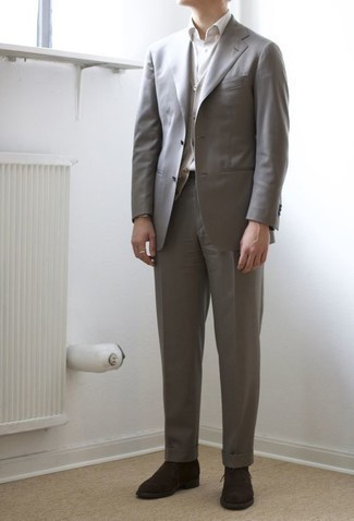 Dunkelbraune Chukka-Stiefel aus Wildleder kombinieren – 117 Elegante Herren Outfits: Kombinieren Sie einen grauen Anzug mit einem grauen Pullunder für einen stilvollen, eleganten Look. Fühlen Sie sich ideenreich? Vervollständigen Sie Ihr Outfit mit dunkelbraunen Chukka-Stiefeln aus Wildleder.