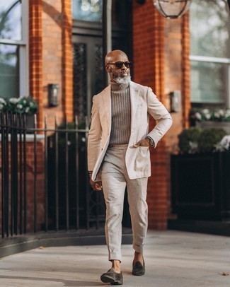 Grauen Rollkragenpullover kombinieren – 99 Elegante Herren Outfits warm Wetter: Kombinieren Sie einen grauen Rollkragenpullover mit einem hellbeige Anzug für eine klassischen und verfeinerte Silhouette. Dunkelgrüne Samt Slipper fügen sich nahtlos in einer Vielzahl von Outfits ein.