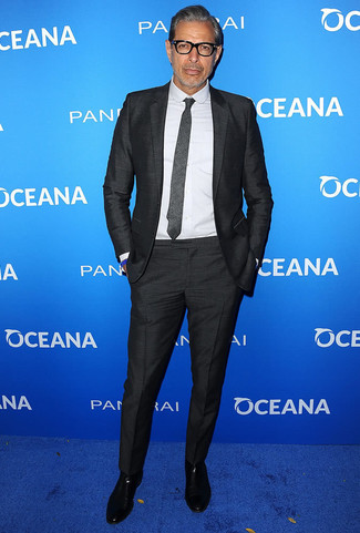 Jeff Goldblum trägt schwarzer Anzug, weißes Businesshemd, schwarze Chelsea-Stiefel aus Leder, dunkelgraue Krawatte