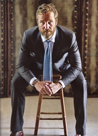 Rainer Andreesen trägt schwarzer Anzug, weißes Businesshemd, dunkelbraune Leder Oxford Schuhe, hellblaue bedruckte Krawatte