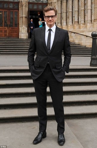 Colin Firth trägt schwarzer Anzug, weißes Businesshemd, schwarze Leder Oxford Schuhe, schwarze gepunktete Krawatte