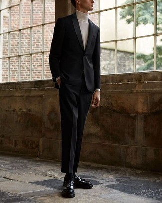 20 Jährige: Schwarzen Anzug kombinieren – 4 Elegante Frühling Herren Outfits: Kombinieren Sie einen schwarzen Anzug mit einem weißen Rollkragenpullover für eine klassischen und verfeinerte Silhouette. Schwarze Leder Slipper mit Quasten sind eine perfekte Wahl, um dieses Outfit zu vervollständigen. Schon mal so einen coolen Übergangs-Outfit gesehen?