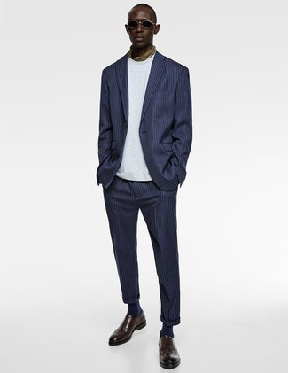Braune Leder Brogues kombinieren – 500+ Herren Outfits: Tragen Sie einen dunkelblauen vertikal gestreiften Anzug und ein weißes T-Shirt mit einem Rundhalsausschnitt für einen für die Arbeit geeigneten Look. Ergänzen Sie Ihr Outfit mit braunen Leder Brogues, um Ihr Modebewusstsein zu zeigen.