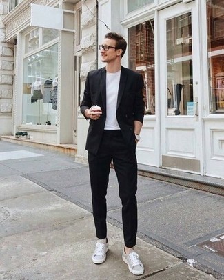 Schwarzen Anzug kombinieren – 224 Smart-Casual Herren Outfits: Kombinieren Sie einen schwarzen Anzug mit einem weißen T-Shirt mit einem Rundhalsausschnitt, wenn Sie einen gepflegten und stylischen Look wollen. Graue Segeltuch niedrige Sneakers verleihen einem klassischen Look eine neue Dimension.