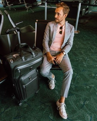 grauer Anzug, rosa T-Shirt mit einem Rundhalsausschnitt, weiße Segeltuch niedrige Sneakers, schwarze Segeltuch Reisetasche für Herren