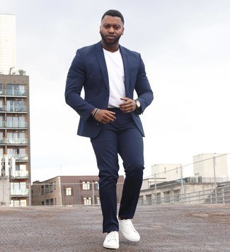Dunkelblauen Anzug kombinieren – 500+ Smart-Casual Herren Outfits: Vereinigen Sie einen dunkelblauen Anzug mit einem weißen T-Shirt mit einem Rundhalsausschnitt für einen für die Arbeit geeigneten Look. Weiße Segeltuch niedrige Sneakers liefern einen wunderschönen Kontrast zu dem Rest des Looks.