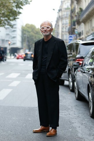 60 Jährige: Schwarzen Anzug kombinieren – 4 Smart-Casual Herren Outfits: Kombinieren Sie einen schwarzen Anzug mit einem schwarzen T-Shirt mit einem Rundhalsausschnitt für einen für die Arbeit geeigneten Look. Fühlen Sie sich ideenreich? Wählen Sie rotbraunen Leder Slipper.