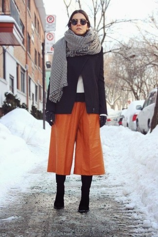 schwarze Wollbikerjacke, orange Hosenrock, schwarze kniehohe Stiefel aus Wildleder, schwarze Lederhandschuhe für Damen