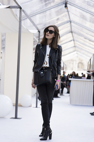 schwarze Leder Bikerjacke, weißes kurzes Oberteil, schwarze enge Jeans mit Destroyed-Effekten, schwarze Leder Stiefeletten für Damen