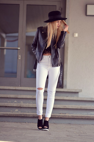 schwarze Leder Bikerjacke, schwarzes kurzes Oberteil aus Spitze, weiße enge Jeans mit Destroyed-Effekten, schwarze Keilsandaletten aus Wildleder für Damen