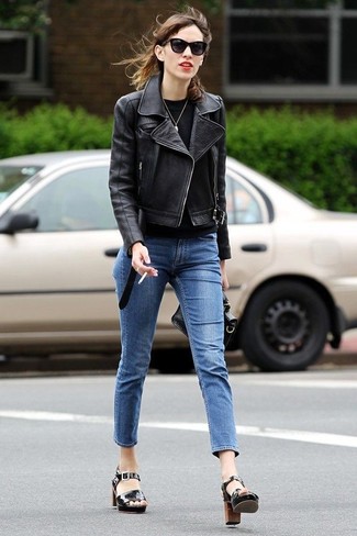Alexa Chung trägt schwarze Leder Bikerjacke, schwarzes Langarmshirt, blaue enge Jeans, schwarze Leder Sandaletten