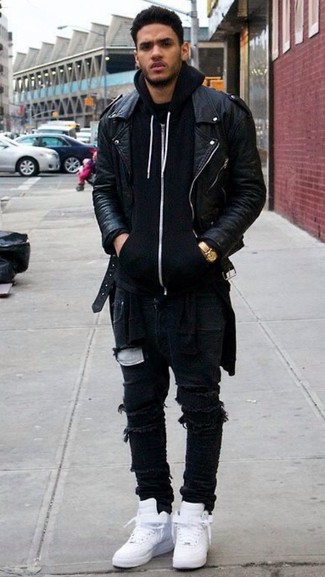 schwarze Leder Bikerjacke, schwarzer Pullover mit einem Kapuze, schwarze enge Jeans mit Destroyed-Effekten, weiße hohe Sneakers für Herren