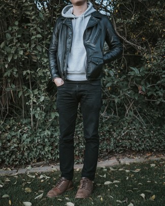 schwarze Leder Bikerjacke, grauer Pullover mit einem Kapuze, schwarze Jeans, braune Leder Derby Schuhe für Herren