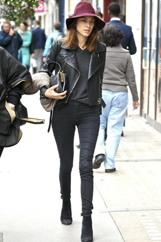 Alexa Chung trägt schwarze Leder Bikerjacke, dunkelgrauer Pullover mit einem V-Ausschnitt, schwarze enge Jeans, schwarze Wildleder Stiefeletten