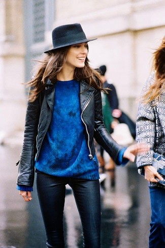 schwarze Leder Bikerjacke, blauer Oversize Pullover, schwarze enge Hose aus Leder, dunkelblauer Wollhut für Damen