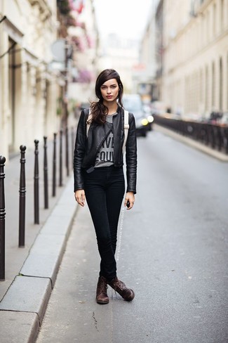 schwarze Leder Bikerjacke, graues bedrucktes T-Shirt mit einem Rundhalsausschnitt, schwarze enge Jeans, dunkelbraune flache Stiefel mit einer Schnürung aus Leder für Damen