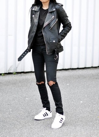 schwarze Leder Bikerjacke, schwarzes T-Shirt mit einem Rundhalsausschnitt, schwarze enge Jeans mit Destroyed-Effekten, weiße und schwarze Leder niedrige Sneakers für Damen